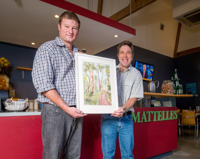 Matthew Bunning (owner of Mattelles Cafe) & Rob Gibbs with a piece of Robs artwork. Photo: Dylan Burns