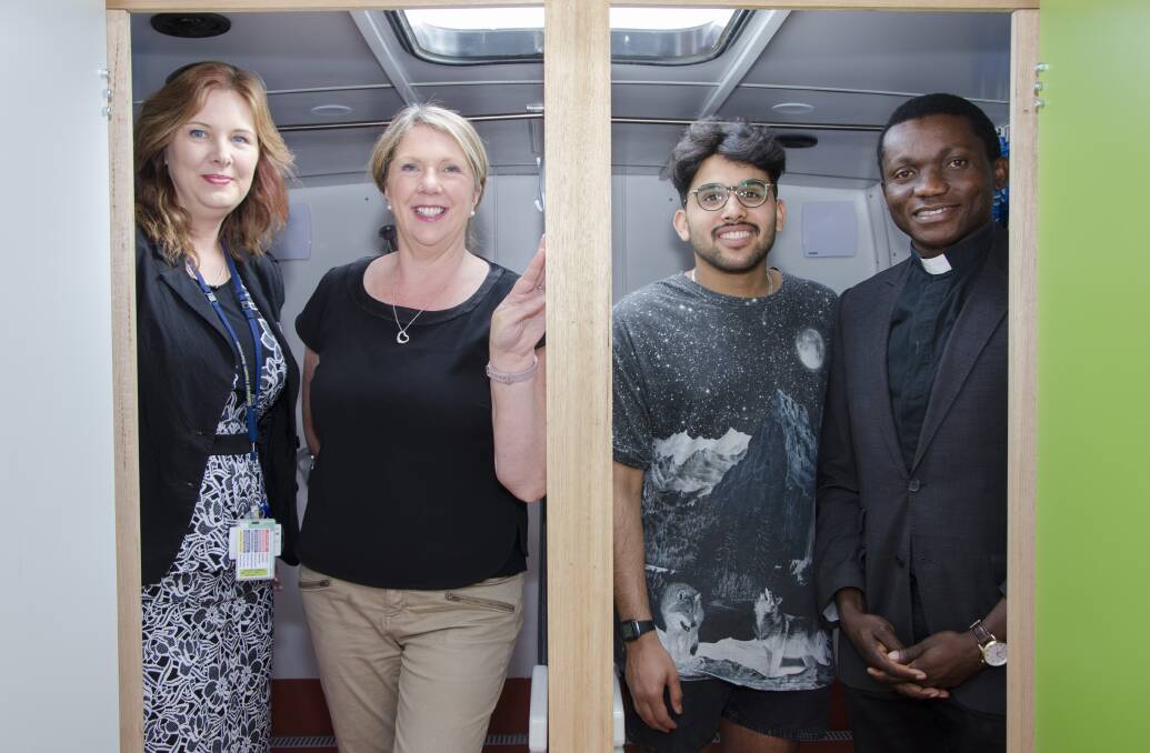 CLEANING UP: Kelly Healy from BHS, MP Catherine King, volunteer Saad Al-Mashouq and Father Constantine Osuchukwu in the shower bus. Picture: Victoria Stone-Meadows. 