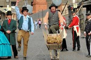 eureka: Matt Farnell and Wes Scott, playing the part of two of the Cornish miners who found Ballarat’s Welcome Nugget, parade a model of the nugget around Sovereign Hill in a wheelbarrow yesterday. Picture: Jeremy Bannister