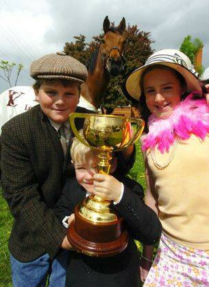 CUP FEVER: The Melbourne Cup, on show at the Skipton Primary School yesterday with pupils Kyle Ponder, left Tim Robertson and Belinda Fraser, who also met Caulfield Cup winner and Melbourne Cup second place getter Paris Lane.