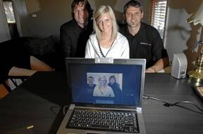 HELPING HAND: David Newbury, left, and  Steve Macdonald from BackItUpOnline  hand over a new laptop to theft victim Kylie Bouker.