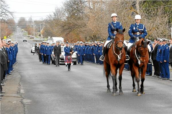 SPECIAL TRIBUTE: Uniformed police members form a guard of honour for the cortege of Sergeant Roger Fuller.