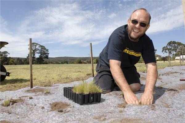 NEW LEASE OF LIFE: Paul Duggan plants kangaroo grass on Saturday at Buninyong's Royal Park Reserve, which has been handed over by the City of Ballarat to the Friends of Royal Park Committee.