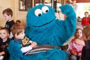 COOKIES:  Local children and Cookie Monster make short work of the biscuits. Picture: Justin Whitelock