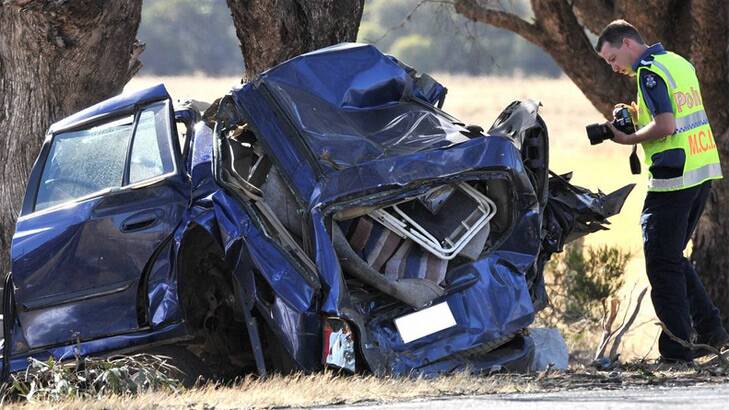 Police inspect a car which two men died in. Photo: Blair Thomson