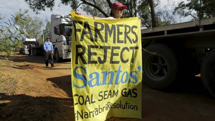 NSW farmers Ted and Julia Borowski (holding banner) protest against Santos' coal seam gas project near the Pilliga State Forest. Photo: Dean Sewell