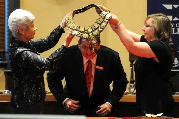 LIKE A GLOVE: Councillor Craig Fletcher receiving the mayoral chains from councillor Judy Verlin and Annie De Jong as he is sworn in as Ballarat's mayor for 2010/11 last night. Picture: Jeremy Bannister