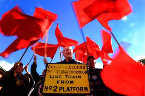 LEADER OF THE PACK: Campaign co-ordinator Max Kau, centre, and  fellow Talbot  residents signal their desire for  trains to stop at their now redundant station. Picture: Andrew Kelly