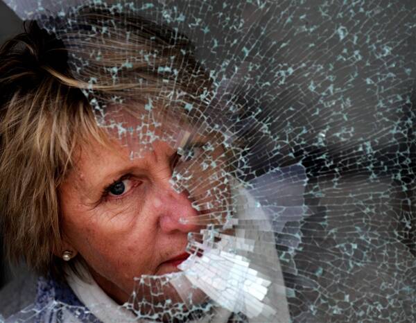 FRUSTRATED: Black Hill Primary School Principal Ann Campbell looks out of one of the 19 windows that vandals broke at the school.  Picture: Andrew Kelly