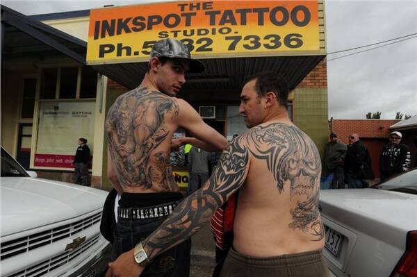 BODY ART: Cameron Davis and David Grima show off their tattoos while, below, people queue outside the Inkspot Tattoo Studio to book an appointment for 2009.