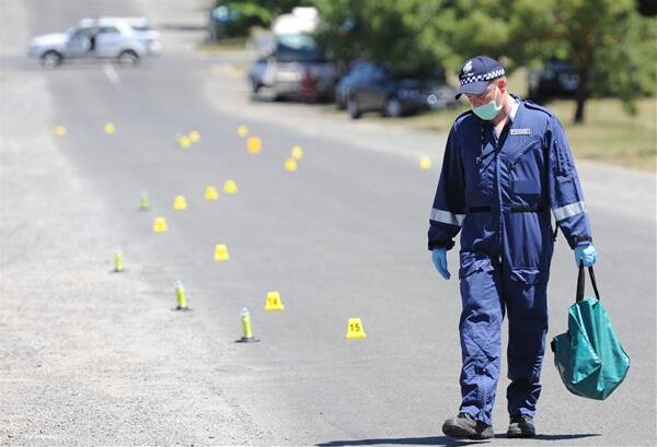SCENE:  A police investigator examines the roadway in Ligar St where two men were shot early yesterday.  Picture: Lachlan Bence