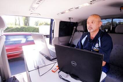 KEEPING WATCH: Victoria Police Automatic Number Plate Recognition Unit  project manager Ray Walker  monitors  the detection equipment in a van during yesterday's operation.