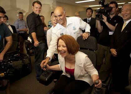 In control ... Julia Gillard gets to grips with a bulldozer simulator in Darwin yesterday.