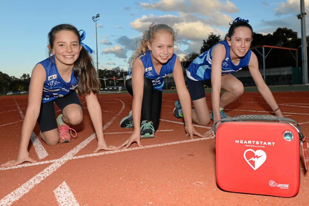 Lifesaver: Young athletes Alice Lepair, 9, Mia Darlow, 9, and Eliza Lepair, 13, with Ballarat Regional Athletic Centre’s new defibrillator at Llanberris Reserve.
PICTURE: KATE HEALY