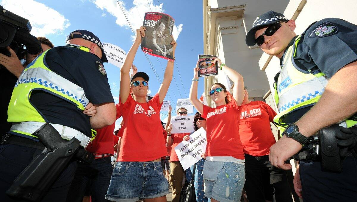 ANGRY: Ambulance officers and firefighters protest outside Western Victoria MP Simon Ramsay’s Dana Street office in Ballarat during a visit by the Premier Denis Napthine yesterday. PICTURE: JUSTIN WHITELOCK