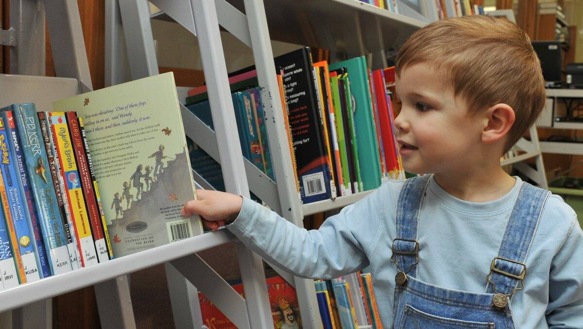 Lincoln Armstrong, 3, picks out a book to read. PICTURE: LACHLAN BENCE.