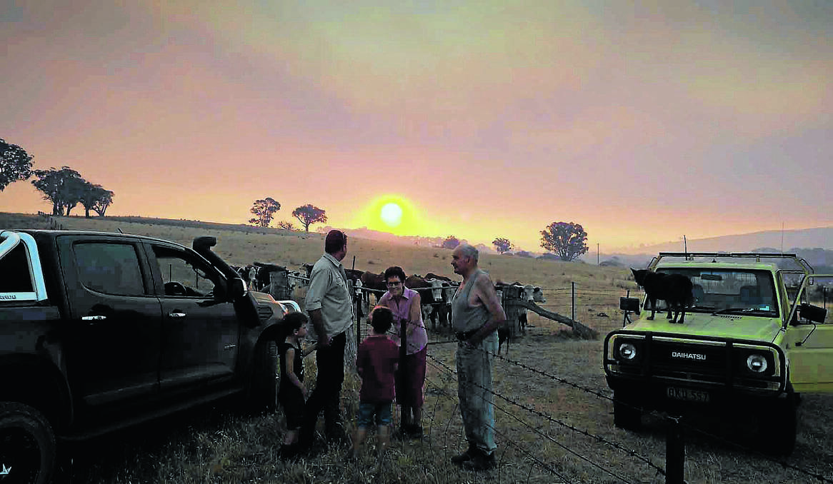 Matt Molloy with his children Oliver, 5, and Mitchell, 7, chat with his parents on the neighbouring property Paul and Deirdre Molloy about the fire at Hells Hole. Photo: ZENIO LAPKA