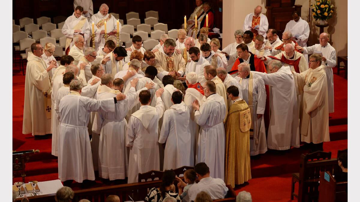 The college of priests lays hands upon Robyn & Anne during the ordination. PIC: ADAM TRAFFORD