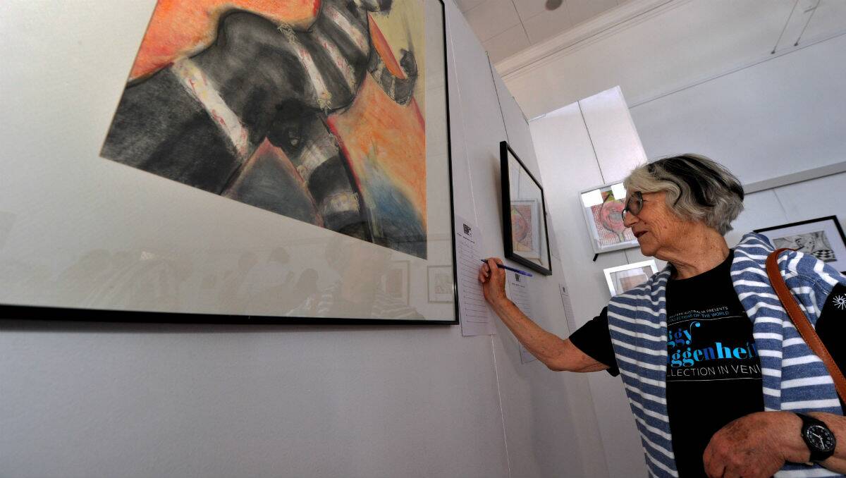 Dulcie Corbett places her bid in the silent auction held at B1 art gallery. PICTURE: JEREMY BANNISTER
