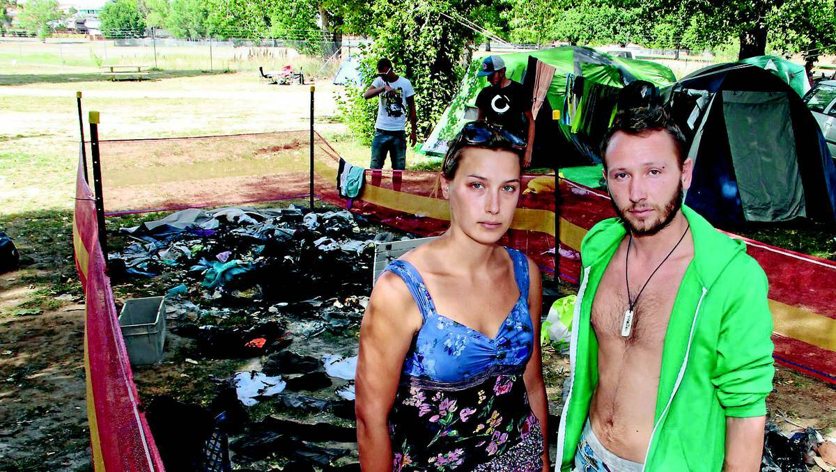 NOTHING LEFT: Backpackers Marie Dufour and Antoine Mickael attempt to salvage any clothes and possessions they can after their tent was destroyed by arsonists on New Year’s Eve. Photo: JACK KEMP