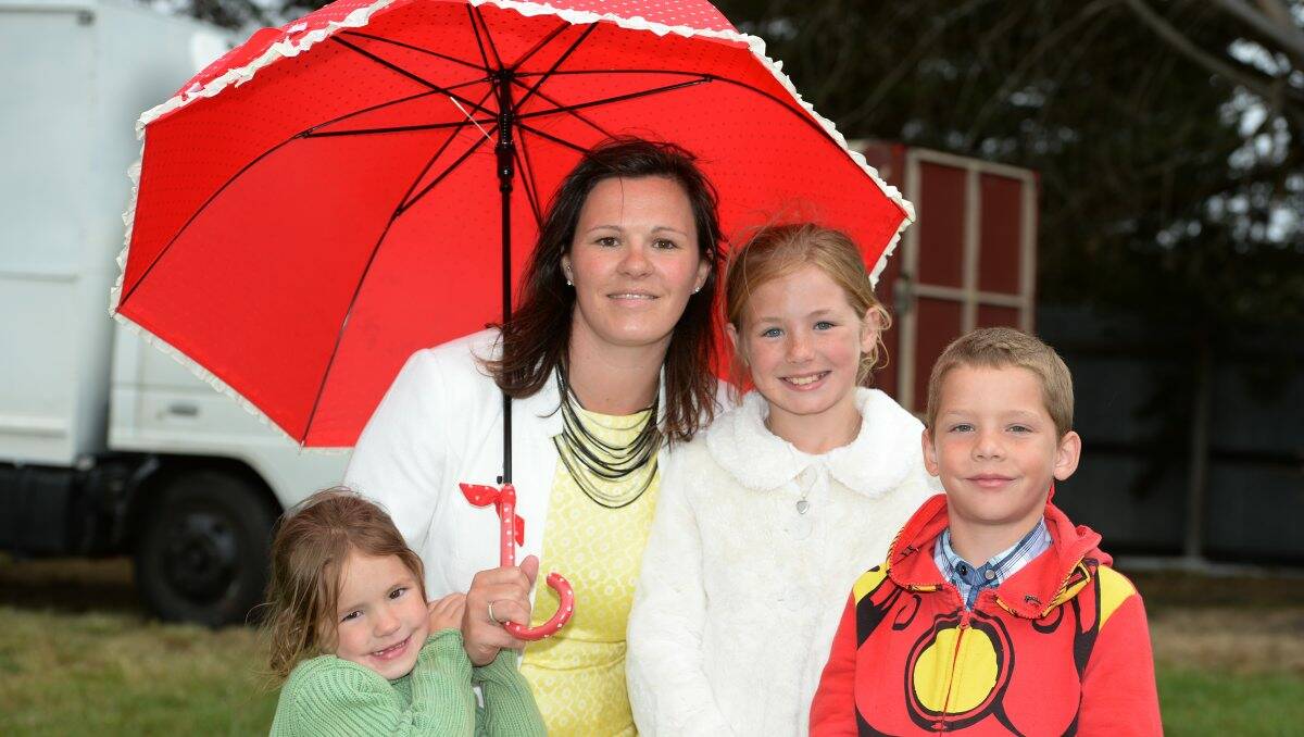 Ebony, 5, Theresa, Ahlia, 9, and Zac Cosway, 7, of Miners Rest, shelter under an umbrella at the races. PICTURES: KATE HEALY