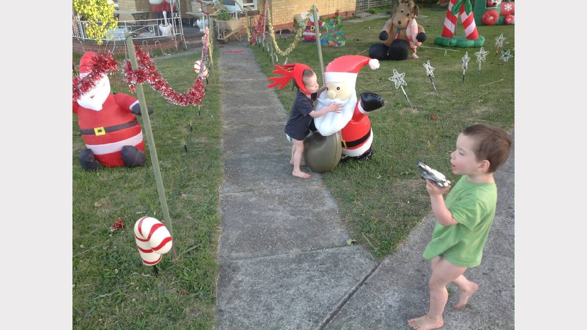 One of my twin sons giving one of the many Santa displays a kiss to show his been a good boy. Submitted by reader Donna Curtis. 
