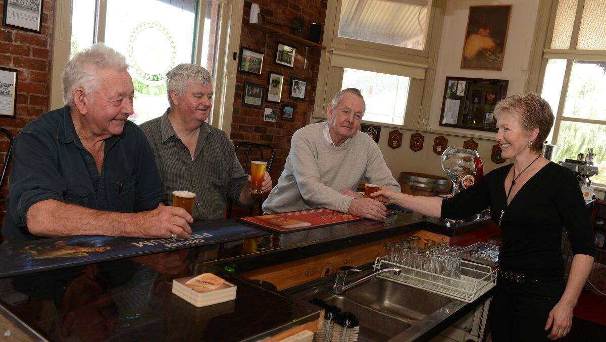 Dunnstown locals Leo Murphy, Pat Leonard and Ray Murphy being served by the Shamrock Hotel's Michaela Johnston. PICTURE: KATE HEALY