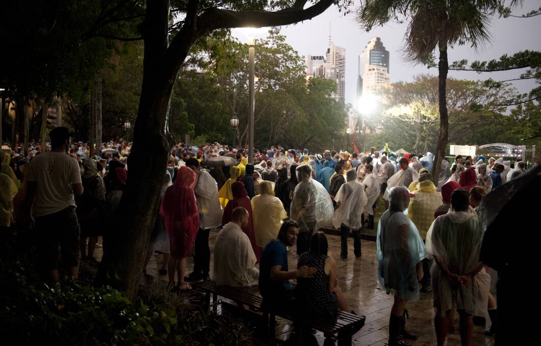 Crowds prepare to re enter after a storm suspended the concerts at the 2012 Harvest Festival held at the city Botanic Gardens in Brisbane. Photo: Harrison Saragossi.