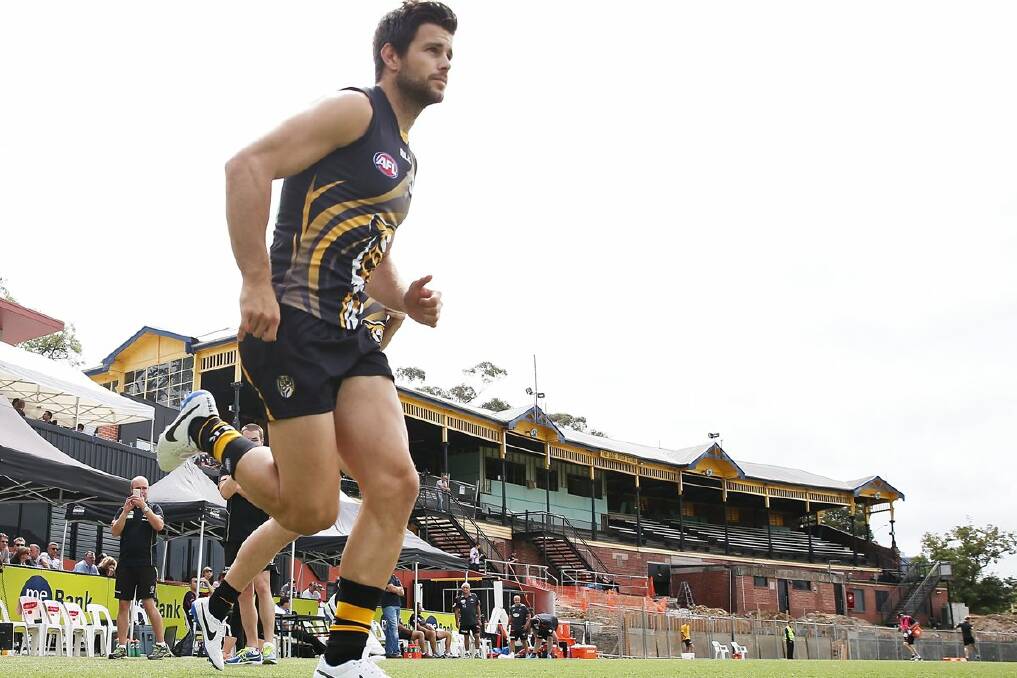 Tigers captain Trent Cotchin runs out onto the grounds during an AFL practice match between Richmond and Essendon at Punt Road Oval.