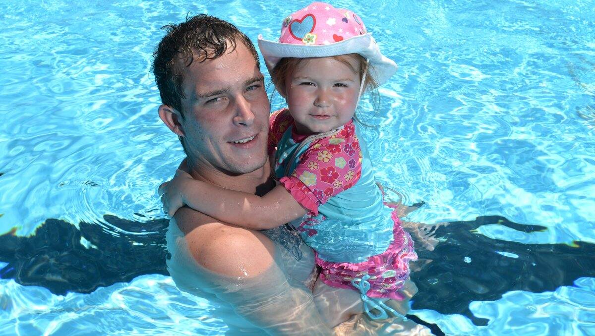 Drew Pearce with daughter Dakodah Pearce, 2, cool down at the pool.