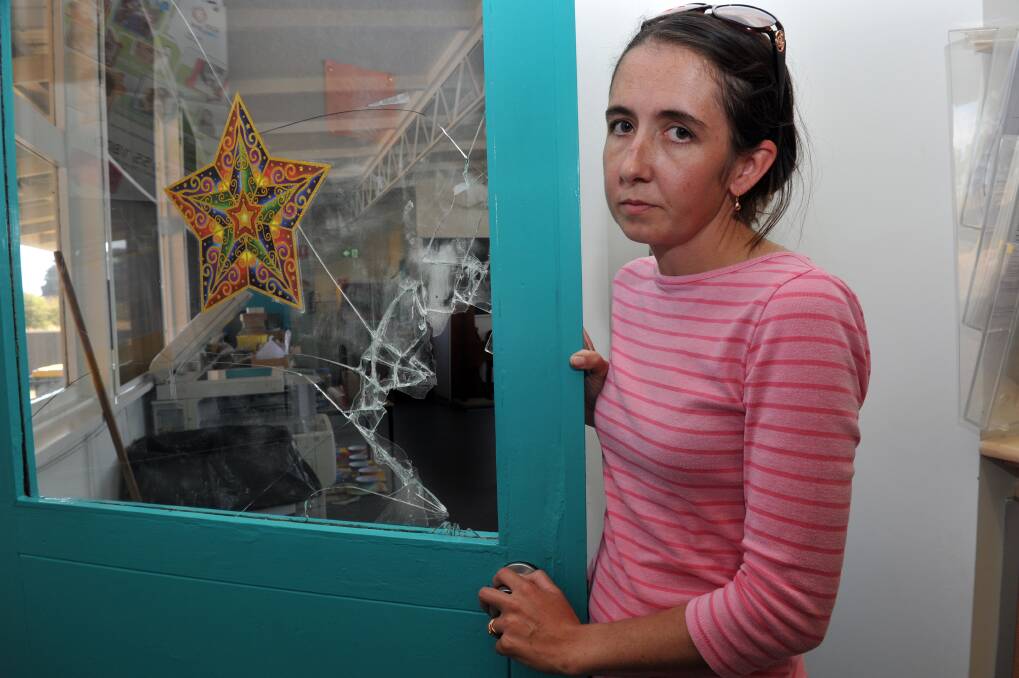 Parent Christine Henderson shows the smashed glass in the door where intruders broke into the music room.