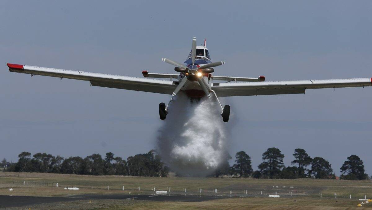One of the two Ballarat-based firefighting aircraft drops a demonstration load of fire retardant and, inset, the view from the plane during Gav McGrath’s up-close-and-personal flight yesterday. PICTURE: JUSTIN WHITELOCK