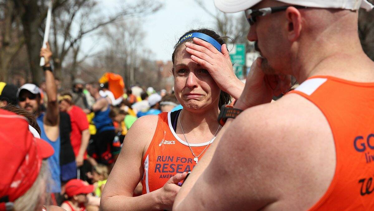 A runner reacts near Kenmore Square after two bombs exploded during the 117th Boston Marathon.