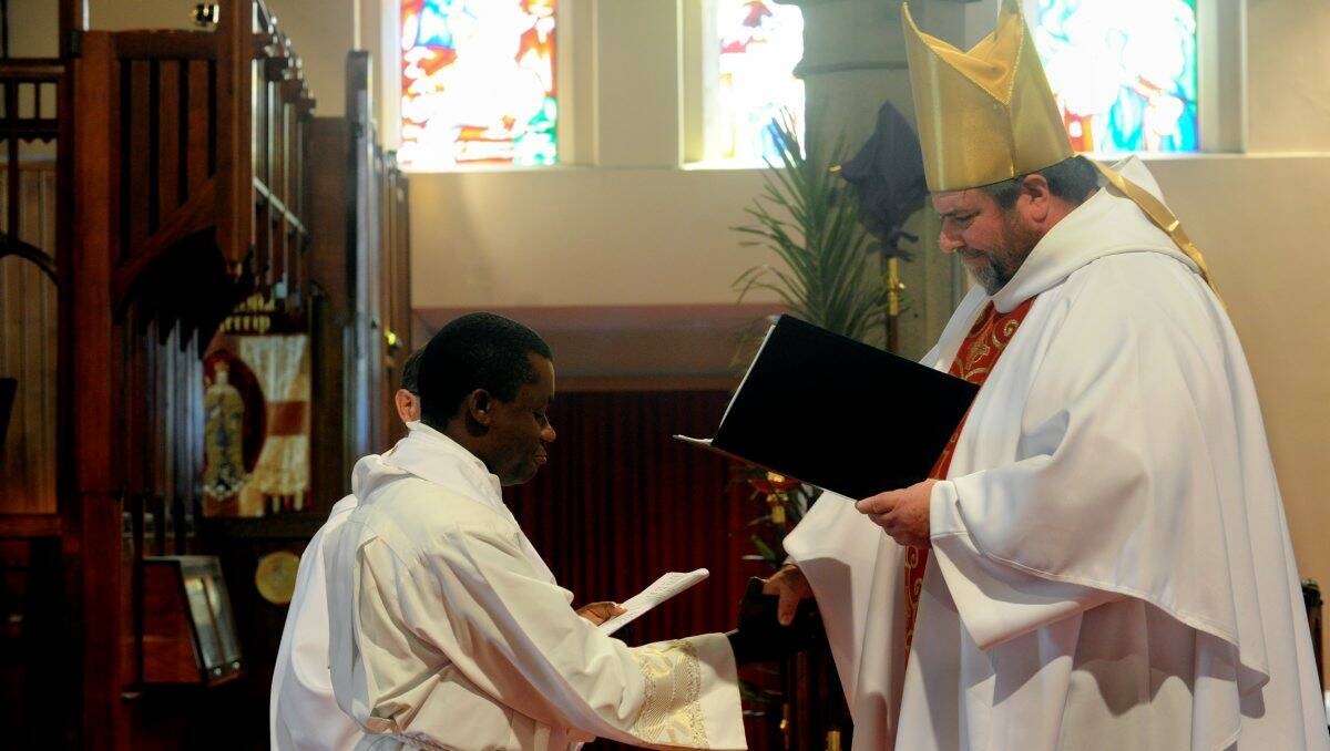Welcomed: Bishop Garry Weatherill blesses former Catholic priest Constantine Osuchukwu, who has joined the Anglican Church, during yesterday’s service. PICTURE: JEREMY BANNISTER