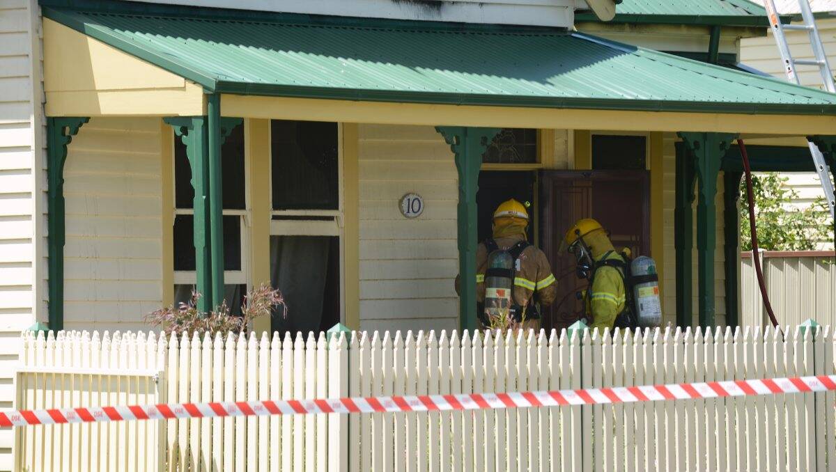 HOUSE FIRE: Firefighters enter the Rice Street house in Ballarat East after a blaze broke out late yesterday morning. PICTURE: ADAM TRAFFORD