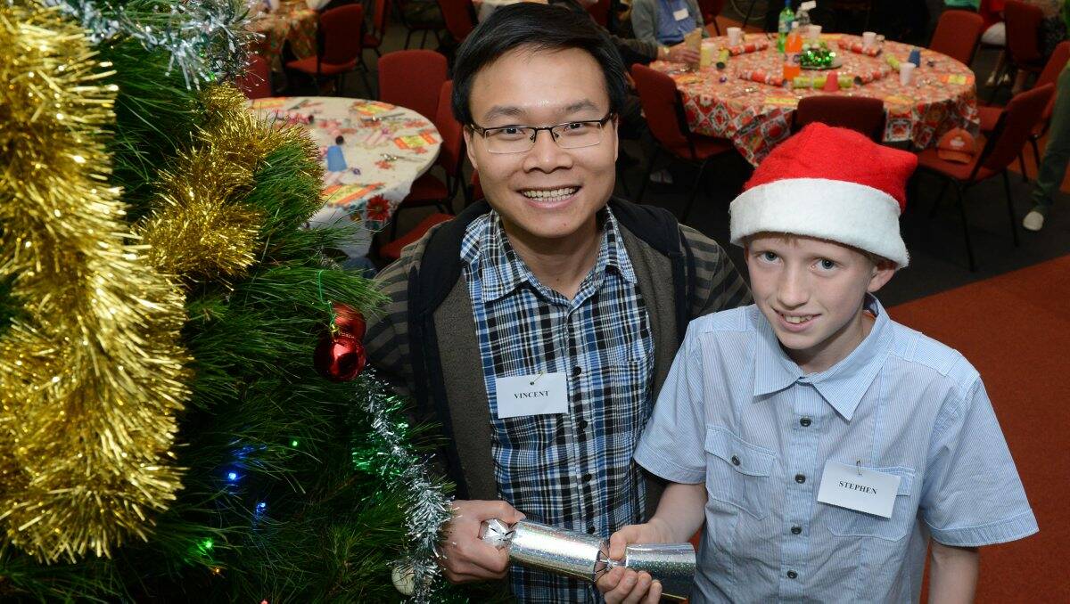  Vincent Long, left, and Stephen Burns, 12, take time out to enjoy a Christmas cracker while helping at the Our Lady Help of Christians Christmas Day lunch for marginalised members of the community. PICTURE: ADAM TRAFFORD