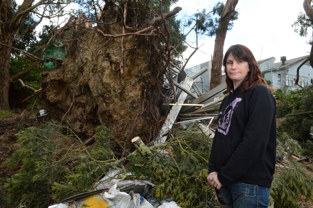 Narelle Dopper with the huge tree down in her father Allan's backyard. PICTURE: ADAM TRAFFORD