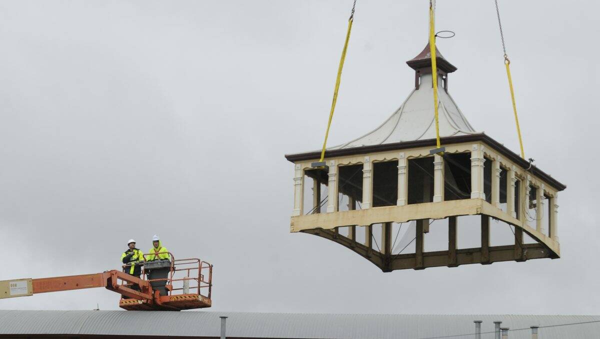 John Allen and Michael Murnane from Ballarat Mobile Cranes oversee the removal of the turrets from the City Oval grandstand yesterday so they can be refurbished.