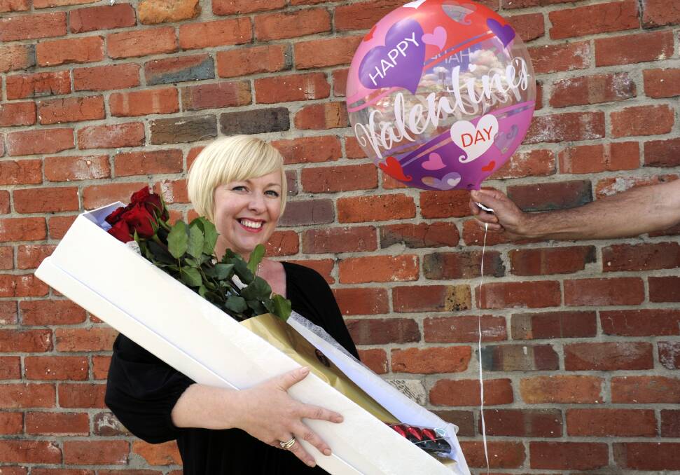 Julie-Anne Giles of Stem’s customer service shows what the luckier women can expect on Thursday as she is presented with a box of red roses and a Valentine’s Day balloon.