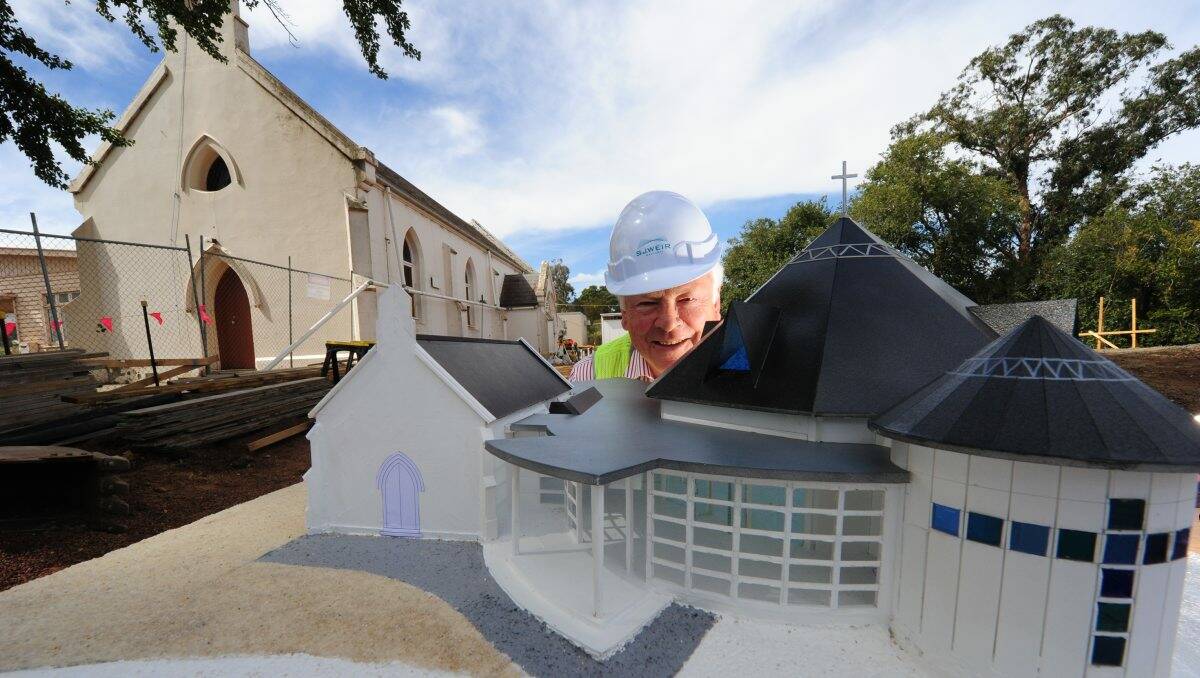 Model plan: Father Adrian McInerney takes a look at a model of the new church that will be built. PICTURE: JEREMY BANNISTER