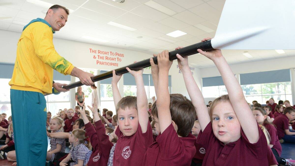 INSPIRING: James Marburg lets Wendouree Primary School pupils Caleb Vercoe, left, Oliver Hearnshaw and Hannah Brown hold his oar from the Beijing Olympics. PICTURE: ADAM TRAFFORD