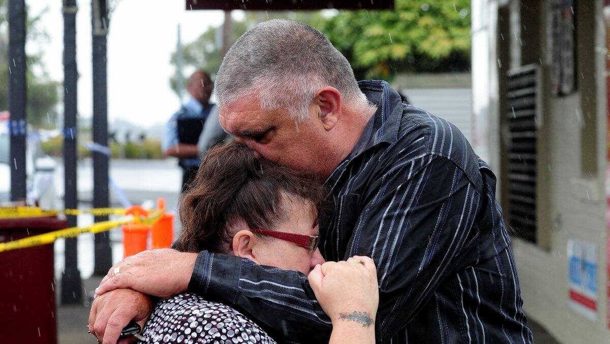 Leigh Rosendale comforts his wife Wendy after she was inside the Black Hill Post Office and General Store during yesterday’s armed hold-up. PICTURE: JEREMY BANNISTER