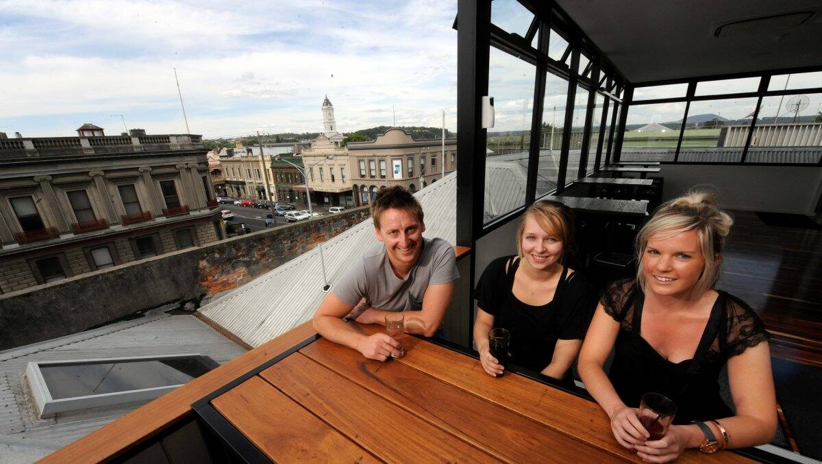 Brian Taylor, Shannon Cassidy and Paige Gibson enjoy the afternoon sun on the rooftop bar at Jackson’s Hotel. The sunshine should continue into the new year, say meteorologists. PICTURE: JEREMY BANNISTER