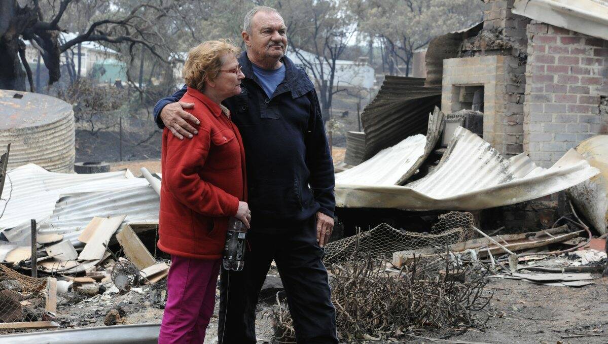 Gayle and Ray Stone among the ruins of their house on Carngham Road.