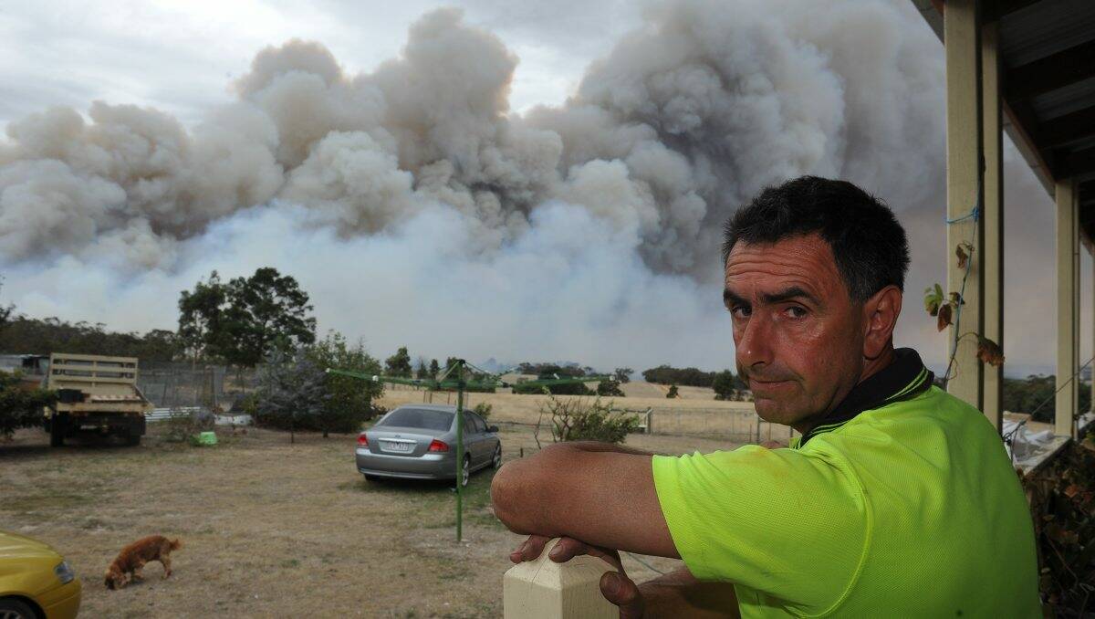 Danger zone: Reno Bugeja watches on as the fire comes dangerously close to his home and property at Dereel yesterday as a  1300ha blaze burns through land and homes in the area. PICTURE: LACHLAN BENCE 