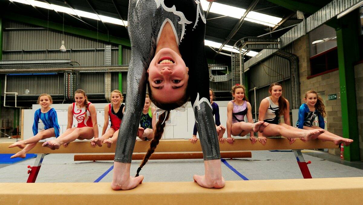 Emma Sherritt, 14, who placed third in the Victorian Championships, on the balance beam aparatus with her Eureka clubmates. PICTURE: JEREMY BANNISTER
