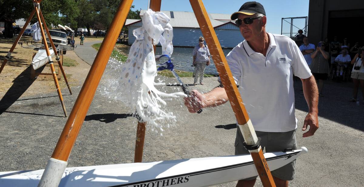 Ballarat City Rowing Club’s Wayne Lyle christens one of the boats at the weekend.