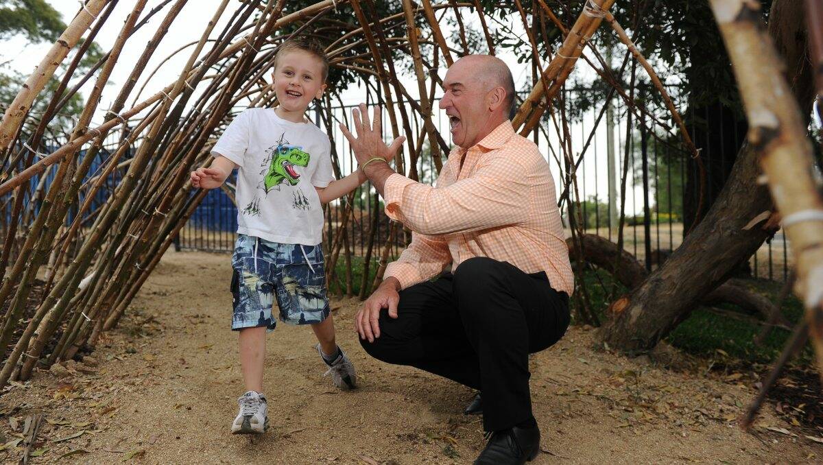 OFFICIALLY OPEN: Oscar Howlett, 5, tries out the bamboo tunnel at Mt Clear Kindergarten with garden designer Wes Fleming. PICTURE: JUSTIN WHITELOCK 