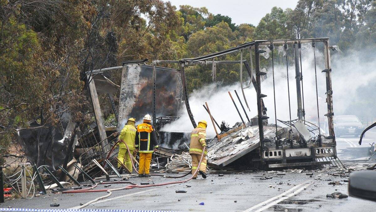 The wreckage of the trucks continues to smoulder more than 12 hours after the crash in Stawell. Picture: BEN KIMBER