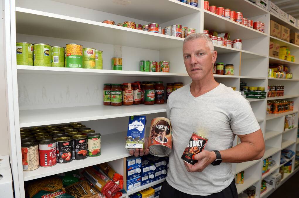 Ballarat Soup Bus founder Craig Schepis holding some commonly sought after items, such as long-life milk and canned goods. Picture by Kate Healy